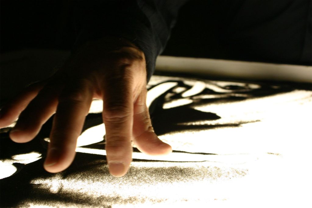 Animació d'arena: manipulant sorra sobre un retroprojector. Font: Tim Grable (Flickr). .