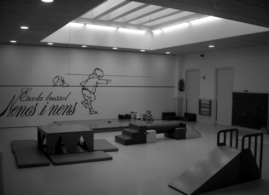 Sala d'usos múltiples de l'EBM Nenes i Nens de Barcelona. Els espais amplis amb mobiliari i equipament específics afavoreixen el moviment i l'estimulen.