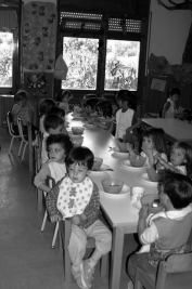 Nens petits asseguts al menjador de l'escola.