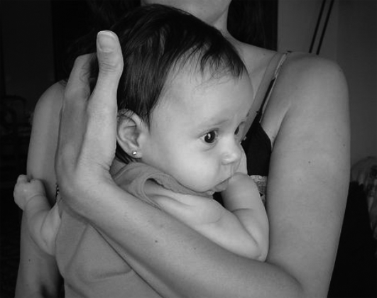 La subjecció del nadó ha de ser suau però ferma. Una dona amb un bebè en braços, tot subjectant-li el cap.