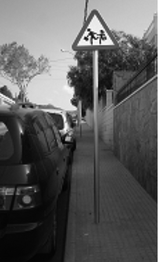 L'infant ha de començar a identificar els senyals de trànsit més habituals. Senyal vertical de perill assenyalant la proximitat d'una escola.