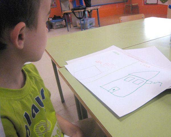 Infant de quatre anys mostrant el seu dibuix.