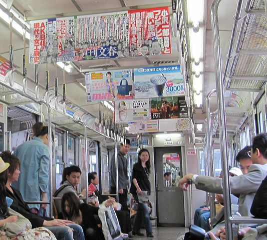 Anunci penjat del sostre d'un vagó del metro.