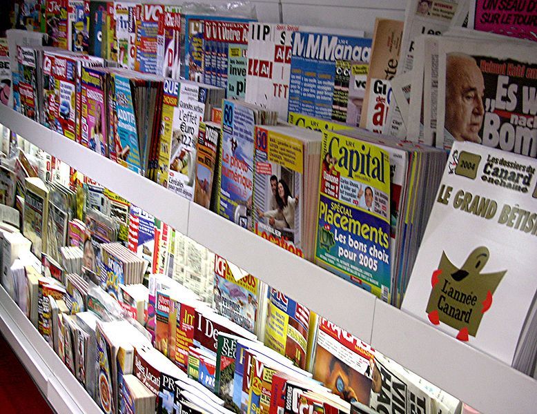 Mostra de diferents revistes en una llibreria. Wikimedia Commons. Mostrador vertical ple de revistes per vendre.