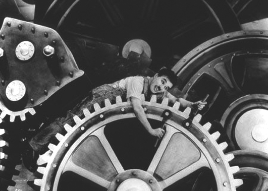 Fotograma de la pel·lícula "Temps moderns" on Charles Chaplin queda atrapat per un gran engranatge.