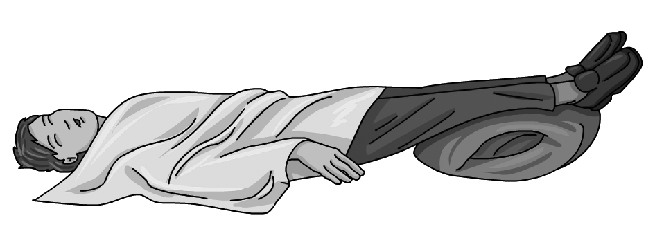 Una persona al terra, abrigada amb una manta i amb els peus una miva elevats.